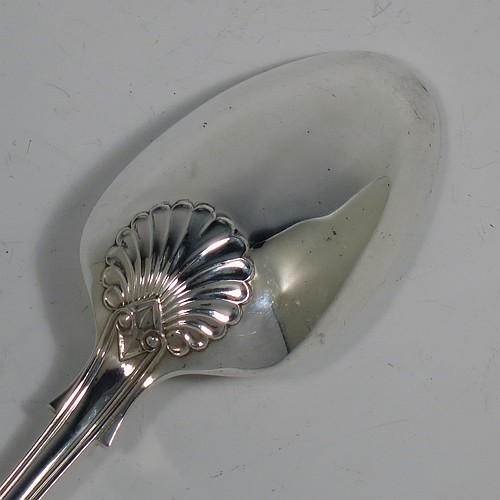 A heavy Sterling Silver stuffing spoon in the double-struck Kings pattern, having a fancy handle with hand-chased shell, scroll, and reeded decoration, and a plain oval bowl with shoulders above, and shell on reverse. Made in London in 1978. The dimensions of this fine hand-made silver stuffing spoon are length 31 cms (12.25 inches), and it weighs approx. 253g (8.2 troy ounces).   