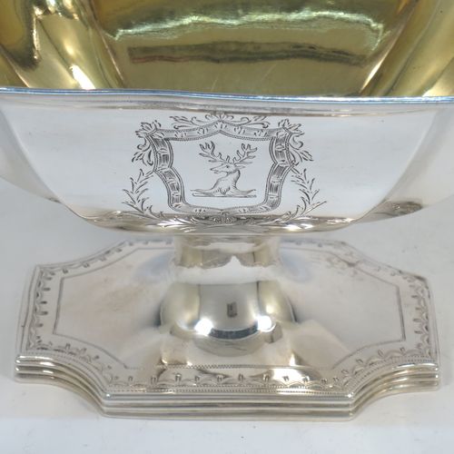 A lovely Antique Georgian Sterling Silver sugar basket, having a shaped rectangular and panelled  body with cut-corners, an applied reeded top border above a band of hand-engraved floral and scroll decoration, a gold-gilt interior, and sitting on a matching pedestal foot. Made by William Frisbee of London in 1794. The dimensions of this fine hand-made antique silver sugar basket are height 14.5 cms (5.75 inches), length 10 cms (4 inches), length 16.5 cms (6.5 inches), width 10 cms (4 inches), and it weighs approx. 258g (8.3 troy ounces).   