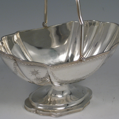 Antique Victorian sterling silver oval hand-engraved sugar basket with swing-handle and pedestal foot. Made by Elkington & Co., of Birmingham in 1864. Height 18 cms (7 inches), length 17 cms (6.75 inches), width 11.5 cms (4.5 inches). Weight approx. 8 troy ounces (248g).