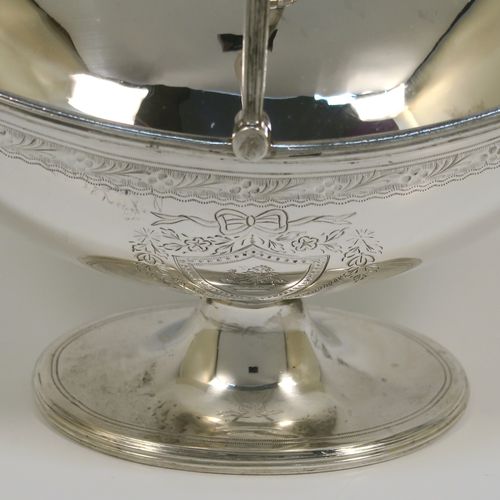 A very pretty Antique Victorian Sterling Silver sugar basket, having an oval body with tapering sides and hand-engraved bright-cut floral style decoration above two cartouches on either side, with applied reeded borders, a hinged and reeded swing-handle, and sitting on a plain oval pedestal foot. This beautiful antique silver sweet-meat basket was made by Joseph Braham of London in 1881. The dimensions of this fine hand-made antique silver sugar basket are height (inc. handle) 15 cms (6 inches), length 16 cms (6.3 inches), width 10 cms (4 inches), and it weighs approx. 178g (5.7 troy ounces). Please note that this item has a part-crest on one side.