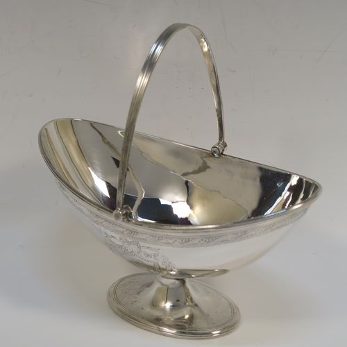 A very pretty Antique Victorian Sterling Silver sugar basket, having an oval body with tapering sides and hand-engraved bright-cut floral style decoration above two cartouches on either side, with applied reeded borders, a hinged and reeded swing-handle, and sitting on a plain oval pedestal foot. This beautiful antique silver sweet-meat basket was made by Joseph Braham of London in 1881. The dimensions of this fine hand-made antique silver sugar basket are height (inc. handle) 15 cms (6 inches), length 16 cms (6.3 inches), width 10 cms (4 inches), and it weighs approx. 178g (5.7 troy ounces). Please note that this item has a part-crest on one side.