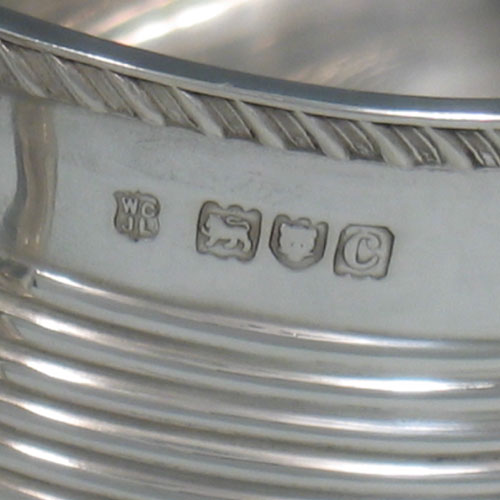 Antique Victorian sterling silver sugar bowl, having a rounded rectangular body, with hand-chased reeded banding, an applied gadroon border, two scroll handles, and sitting on four ball feet. Made by Goldsmiths & Silversmiths of London in 1898. The dimensions of this fine hand-made silver sugar bowl are length 18 cms (7 inches), height 10 cms (4 inches), and it weighs approx. 290g (9.4 troy ounces).