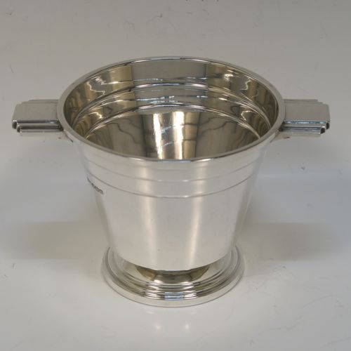 A very stylish Art Deco Sterling Silver sugar bowl, having a round body with tapering sides, with hand-chased reeded decoration, with two cast and stepped side-handles, and sitting on a pedestal foot. This very elegant Art Deco sugar bowl was made by Walker and Hall of Sheffield in 1943. The dimensions of this fine hand-made silver sugar bowl are height 8.5 cms (3.3 inches), diameter at top 10 cms (4 inches), and it weighs approx. 210g (6.8 troy ounces).   