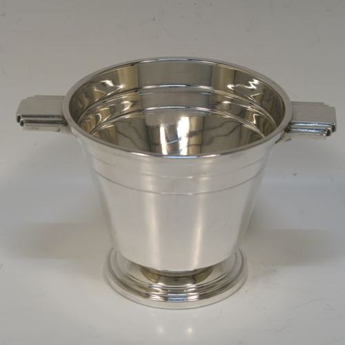 A very stylish Art Deco Sterling Silver sugar bowl, having a round body with tapering sides, with hand-chased reeded decoration, with two cast and stepped side-handles, and sitting on a pedestal foot. This very elegant Art Deco sugar bowl was made by Walker and Hall of Sheffield in 1943. The dimensions of this fine hand-made silver sugar bowl are height 8.5 cms (3.3 inches), diameter at top 10 cms (4 inches), and it weighs approx. 210g (6.8 troy ounces).   