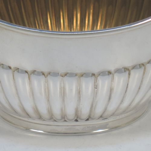 A handsome Antique Edwardian Sterling Silver sugar bowl in a Queen Anne style, having an oval body with hand-chased half-fluted decoration and a gold-gilt interior, two side handles with reeded decoration, and sitting on a collet foot. Made by Goldsmiths and Silversmiths of London in 1908. The dimensions of this fine hand-made antique silver sugar bowl are length 15 cms (6 inches), width 9.5 cms (3.75 inches), height eight 8.5 cms (3.3 inches), and it weighs approx. 157g (5 troy ounces).