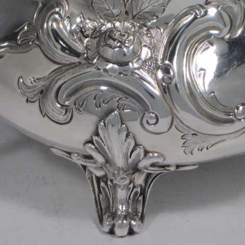 Antique Victorian sterling silver sugar bowl, having a round bellied hand-chased body with floral decoration, scroll handles, and sitting on scroll feet. Made by Martin Hall & Co., of Sheffield in 1856. The dimensions of this fine hand-made silver sugar bowl are height 13.5 cms (5.25 inches), width 22 cms (8.6 inches), and it weighs approx. 436g (14 troy ounces).