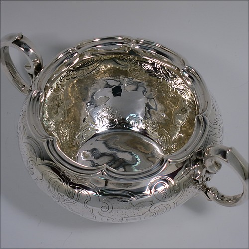 An Antique late Georgian (William IV) Sterling Silver sugar bowl, having a round bellied body with hand-chased floral decoration, an applied lobed top border, with two scroll side handles, and sitting on a collet foot. Made by the Barnard Brothers of London in 1837. The dimensions of this fine hand-made antique silver sugar bowl are height 10 cms (4 inches), width across handles 21.5 cms (8.5 inches), and it weighs approx. 374g (12 troy ounces).   