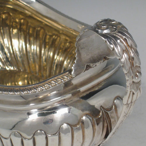 Antique Georgian sterling silver sugar bowl, having a rounded rectangular and baluster body, with hand-chased converging flute decoration, cast shell feet & foliate handles, and gold-gilt interior. Made by Crispin Fuller of London in 1819. The dimensions of this fine hand-made silver sugar bowl are length (inc. handles) 19 cms (7.5 inches), height 11.5 cms (4.5 inches), width 11.5 cms (4.5 inches), and the weight is approx. 12 troy ounces (372g).