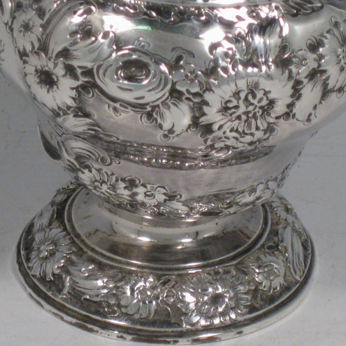 Antique Georgian sterling silver pair of sugar casters, having round baluster shape hand-chased bodies with floral decoration, with pierced pull-off lids and cast finials, all sitting on matching pedestal feet. Made by Samuel Taylor of London in 1750. The dimensions of these fine hand-made silver sugar casters are height 14 cms (5.5 inches), diameter of body 8 cms (3 inches), and they weigh a total of approx. 460g (14.8 troy ounces). Please note that they are both crested and that the lids are not hallmarked. These may have originally been made as a pair of tea caddies with lids pierced at a later date.