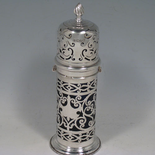 Antique Edwardian sterling silver sugar caster, having a round straight-sided body with hand-pierced decoration, a blue-glass liner, and a bayonet-fit hand-pierced pull-off lid with a cast knurl finial. Made by the Haseler Brothers of London in 1905. The dimensions of this fine hand-made silver sugar caster are height 17 cms (6.75 inches), diameter 5 cms (2 inches), and it weighs approx. 123g (4 troy ounces).  