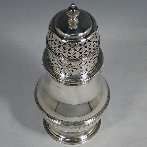 An Antique Edwardian Sterling Silver large sugar caster in a George II style, having a bellied body with hand-chased lower fluting, with applied reeded borders, a bayonet-fit pull-off hand-pierced lid with cast finial, and sitting on a pedestal foot. Made by Nathan & Hayes of Chester in 1904. The dimensions of this fine hand-made antique silver sugar caster are height 20.5 cms (8 inches), width 8 cms (3 inches), and it weighs approx. 328g (10.6 troy ounces).    