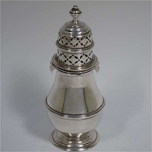 A heavy Antique Victorian Britannia Standard Silver sugar caster, having a plain round bellied body with an applied reeded central girdle, a hand-pierced lid with bayonet fit and cast urn-shaped finial, and sitting on a pedestal foot. Made by Charles Stuart Harris of London in 1900. The dimensions of this fine hand-made antique silver sugar caster are height 14 cms (5 inches), diameter of belly 6 cms (2.3 inches), and it weighs approx. 197g (6.4 troy ounces).    