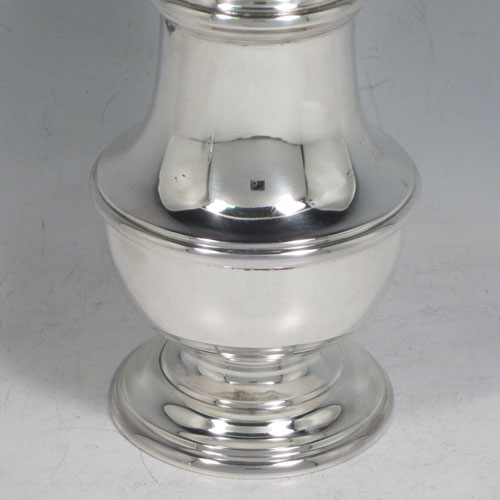 Sterling silver pair of large sugar casters in a George II style, having plain baluster bodies, pull-off hand-pierced lids with urn finials, and sitting on pedestal feet. Made by C. J. Vander of London in 1960. The dimensions of this fine pair of hand-made silver sugar casters are height 18 cms (7 inches), width 7 cms (2.75 inches), with a total weight of approx. 375g (12 troy ounces).