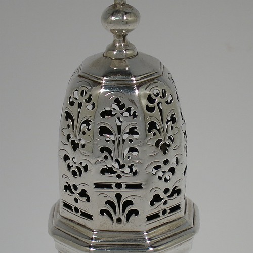 An Antique Georgian Sterling Silver George I heavy sugar caster, having a plain octagonal panelled and bellied body with applied and hand-chased reeded borders, a pull-off hand-pierced lid with cast octagonal finial, and all sitting on a pedestal foot. Made by Thomas Banford of London in 1725. The dimensions of this fine hand-made antique silver sugar caster are height 17 cms (6.75 inches), width 6.5 cms (2.5 inches), and it weighs approx. 243g (7.8 troy ounces). Please note that this item is crested.   