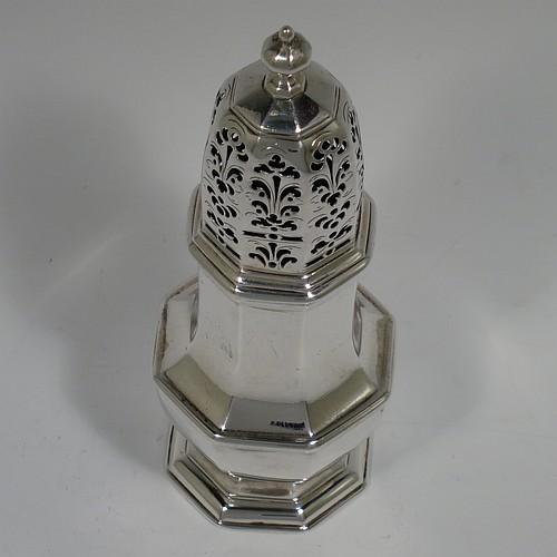 An Antique Georgian Sterling Silver George I heavy sugar caster, having a plain octagonal panelled and bellied body with applied and hand-chased reeded borders, a pull-off hand-pierced lid with cast octagonal finial, and all sitting on a pedestal foot. Made by Thomas Banford of London in 1725. The dimensions of this fine hand-made antique silver sugar caster are height 17 cms (6.75 inches), width 6.5 cms (2.5 inches), and it weighs approx. 243g (7.8 troy ounces). Please note that this item is crested.   