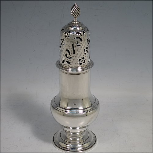 An Antique Georgian Sterling Silver heavy sugar caster, having a plain bellied body with applied and hand-chased reeded borders, a pull-off hand-pierced lid with cast swirl finial, all sitting on a pedestal foot. Made by Robert Peaston of London in 1770. The dimensions of this fine hand-made antique silver sugar caster are height 18 cms (7 inches), width 6 cms (2.3 inches), and it weighs approx. 219g (7 troy ounces).   