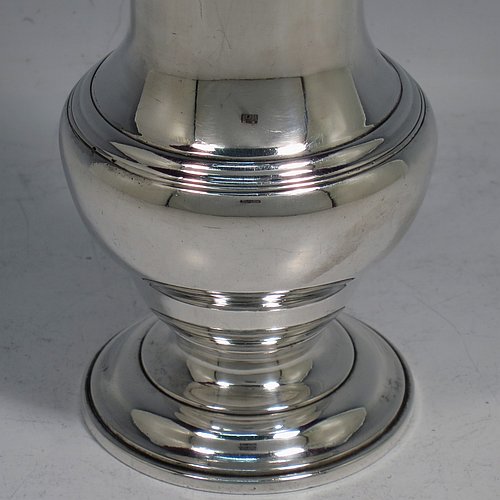 An Antique Georgian Sterling Silver heavy sugar caster, having a plain bellied body with applied and hand-chased reeded borders, a pull-off hand-pierced lid with cast swirl finial, all sitting on a pedestal foot. Made by Robert Peaston of London in 1770. The dimensions of this fine hand-made antique silver sugar caster are height 18 cms (7 inches), width 6 cms (2.3 inches), and it weighs approx. 219g (7 troy ounces).   