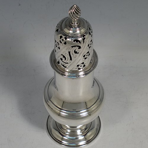 An Antique Georgian Sterling Silver heavy sugar caster, having a plain bellied body with applied and hand-chased reeded borders, a pull-off hand-pierced lid with cast swirl finial, all sitting on a pedestal foot. Made by Robert Peaston of London in 1770. The dimensions of this fine hand-made antique silver sugar caster are height 18 cms (7 inches), width 6 cms (2.3 inches), and it weighs approx. 219g (7 troy ounces).   