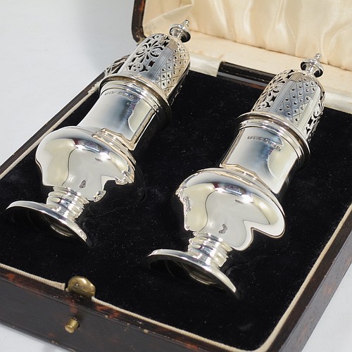 A very handsome pair of Sterling Silver sugar casters in a George II style, having plain round baluster bodies, pull-off hand-pierced lids with urn finials, and sitting on pedestal feet, all in their original cream satin and black velvet-lined presentation box. Made by B. Streete and Co., of Birmingham in 1930. The dimensions of this fine pair of hand-made silver sugar casters are height 14 cms (5.5 inches), width 5 cms (2 inches), with a total weight of approx. 178g (5.7 troy ounces). Please note that silk retainer hinge of the box is damaged.  