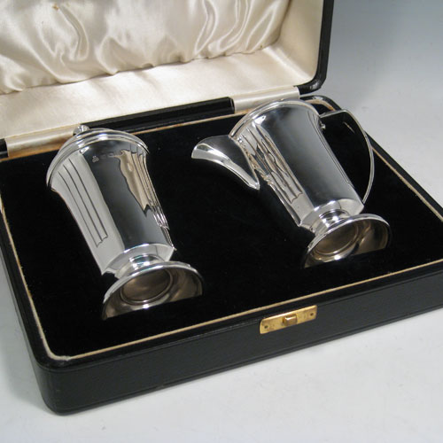 Sterling silver pair of Art Deco sugar caster and creamer set, having plain round bodies with tapering sides and reeded hand-chased decoration, a pull-off hand-pierced lid on the caster and a loop handle on the creamer, all sitting on round pedestal feet, and in their original satin and velvet-lined presentation box. Made in Birmingham in 1938. The dimensions of this fine hand-made silver sugar caster and cream jug set are height of caster 14 cms (5.5 inches), length of cream jug (11 cms (4.3 inches), and the total weight is approx. 217g (7 troy ounces).  