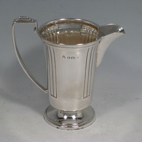 Sterling silver pair of Art Deco sugar caster and creamer set, having plain round bodies with tapering sides and reeded hand-chased decoration, a pull-off hand-pierced lid on the caster and a loop handle on the creamer, all sitting on round pedestal feet, and in their original satin and velvet-lined presentation box. Made in Birmingham in 1938. The dimensions of this fine hand-made silver sugar caster and cream jug set are height of caster 14 cms (5.5 inches), length of cream jug (11 cms (4.3 inches), and the total weight is approx. 217g (7 troy ounces).  