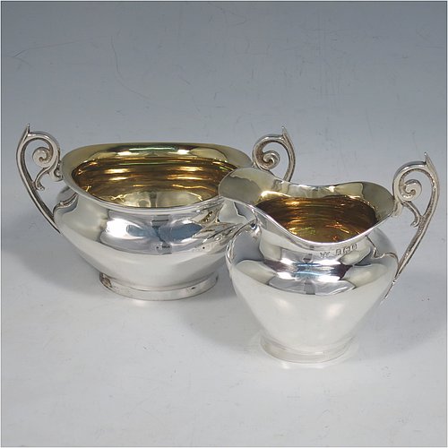 An Antique Edwardian Sterling Silver sugar and creamer set, having plain oval shaped bellied bodies, with gold-gilt interiors and scroll handles, and all sitting on flat bases. Made by Jones & Crompton of Birmingham in 1904. The dimensions of this fine hand-made antique silver tea set are length of sugar bowl 12 cms (4.75 inches), height 7.5 cms (3 inches), and the total weight is approx. 185g (6 troy ounces).   