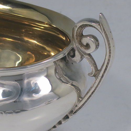 An Antique Edwardian Sterling Silver sugar and creamer set, having plain oval shaped bellied bodies, with gold-gilt interiors and scroll handles, and all sitting on flat bases. Made by Jones & Crompton of Birmingham in 1904. The dimensions of this fine hand-made antique silver tea set are length of sugar bowl 12 cms (4.75 inches), height 7.5 cms (3 inches), and the total weight is approx. 185g (6 troy ounces).   