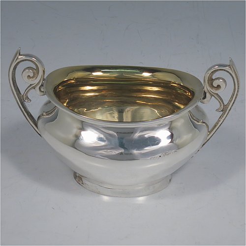 An Antique Edwardian Sterling Silver sugar and creamer set, having plain oval shaped bellied bodies, with gold-gilt interiors and scroll handles, and all sitting on flat bases. Made by Jones & Crompton of Birmingham in 1904. The dimensions of this fine hand-made antique silver tea set are length of sugar bowl 12 cms (4.75 inches), height 7.5 cms (3 inches), and the total weight is approx. 185g (6 troy ounces).   