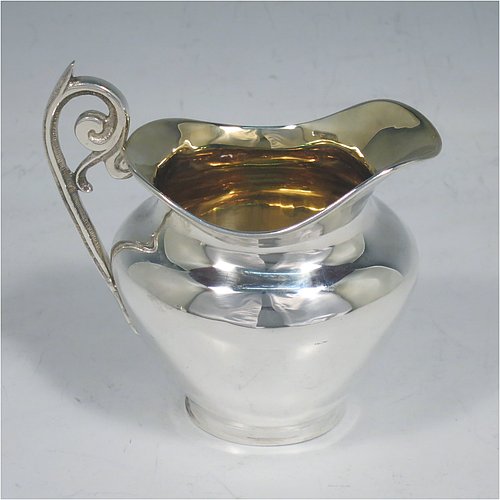 An Antique Edwardian Sterling Silver sugar and creamer set, having plain oval shaped bellied bodies, with gold-gilt interiors and scroll handles, and all sitting on flat bases. Made by Jones & Crompton of Birmingham in 1904. The dimensions of this fine hand-made antique silver tea set are length of sugar bowl 12 cms (4.75 inches), height 7.5 cms (3 inches), and the total weight is approx. 185g (6 troy ounces).   