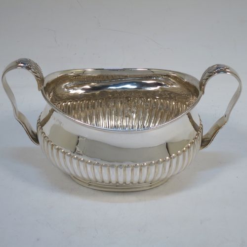 A pretty Antique Victorian Sterling Silver sugar bowl and cream jug set, having oval bellied bodies with hand-chased half-fluted decoration, applied rope-twist  borders, scroll side-handles with anthemion leaf thumb-pieces, and all sitting on collet feet. Made by Frederick Bradford Macrea of London in 1887. The dimensions of this fine hand-made antique silver sugar and creamer set are length of sugar bowl (inc. handles) 16.5 cms (6.5 inches), height 9 cms (3.5 inches), width 9.5 cms (3.75 inches), and with a total weight of approx. 310g (10 troy ounces).  