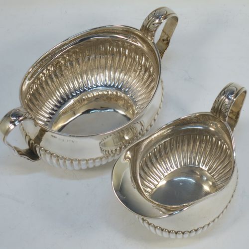 A pretty Antique Victorian Sterling Silver sugar bowl and cream jug set, having oval bellied bodies with hand-chased half-fluted decoration, applied rope-twist  borders, scroll side-handles with anthemion leaf thumb-pieces, and all sitting on collet feet. Made by Frederick Bradford Macrea of London in 1887. The dimensions of this fine hand-made antique silver sugar and creamer set are length of sugar bowl (inc. handles) 16.5 cms (6.5 inches), height 9 cms (3.5 inches), width 9.5 cms (3.75 inches), and with a total weight of approx. 310g (10 troy ounces).  