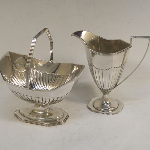 A very pretty Antique Victorian Sterling Silver sugar basket and cream jug set, having Neoclassical style panelled bodies with hand-chased half-fluted decoration, with applied reeded borders, the sugar basket with a swing-handle, and all sitting on pedestal feet. This elegant antique silver cream and sugar set was made by Frederick Elkington of London in 1884. The dimensions of this fine hand-made antique silver sugar and creamer set are height of cream jug 12.5 cms (5 inches), length of sugar basket 12 cms (4.75 inches), with a total weight of approx. 252g (8.1 troy ounces).   