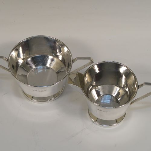 An elegant Sterling Silver pair of Art Deco sugar bowl and creamer set, having plain round bodies with tapering sides and reeded hand-chased decoration, with geometrical side-handles, and all sitting on round pedestal feet. This handsome silver sugar and cream set was made by A. L. Davenport of Birmingham in 1931. The dimensions of this fine hand-made silver sugar bowl and cream jug set are height of cream jug 8 cms (3 inches), width of sugar bowl 15 cms (6 inches), and the total weight is approx. 215g (7 troy ounces).   