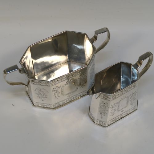 A very pretty Antique Victorian Sterling Silver sugar and creamer set, having octagonal panelled bodies with straight sides and hand-engraved floral decoration, with applied reeded borders, scoll sider handles, and all sitting on flat bases. This beautiful sugar and cream set was made by Henry William Curry of London in 1882. The dimensions of this fine hand-made antique silver cream and sugar set are height of creamer 9.5 cms (3.75 inches), length of sugar bowl 16.5 cms (6.5 inches), and with a total weight approx. 336g (10.8 troy ounces).   