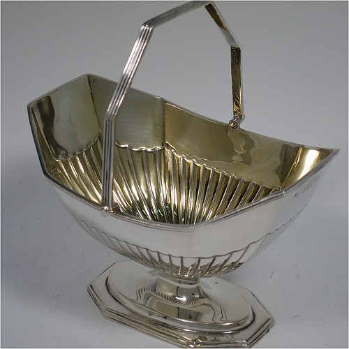 An Antique Victorian Sterling Silver sugar basket and cream jug set, having Neoclassical style panelled bodies with hand-chased half-fluted decoration, with applied reeded borders and gold-gilt interiors, the sugar basket with a swing-handle, and all sitting on pedestal feet. Made by Thomas Bradbury of London in 1897. The dimensions of this fine hand-made antique silver sugar and creamer set are height of cream jug 12.5 cms (5 inches), length of sugar basket 12.5 cms (5 inches), with a total weight of approx. 256g (8.3 troy ounces).    