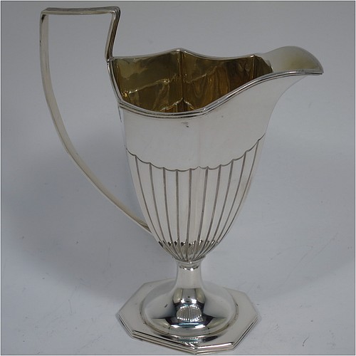 An Antique Victorian Sterling Silver sugar basket and cream jug set, having Neoclassical style panelled bodies with hand-chased half-fluted decoration, with applied reeded borders and gold-gilt interiors, the sugar basket with a swing-handle, and all sitting on pedestal feet. Made by Thomas Bradbury of London in 1897. The dimensions of this fine hand-made antique silver sugar and creamer set are height of cream jug 12.5 cms (5 inches), length of sugar basket 12.5 cms (5 inches), with a total weight of approx. 256g (8.3 troy ounces).    