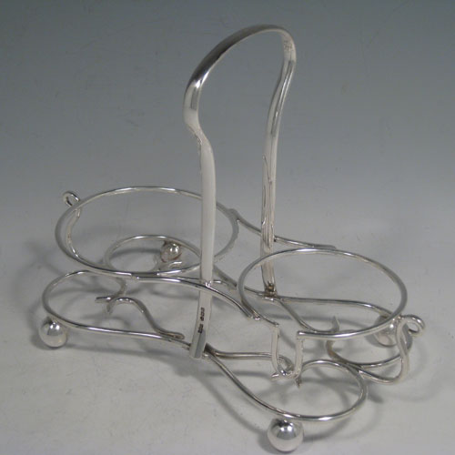 Sterling silver sugar and cream set in a frame, having round panelled bodies with scroll edges, and flat bases, all sitting in an original wire-work frame on four ball feet. Made by James Dixon and Sons of Sheffield in 1913. Height 18 cms (7 inches), length 22 cms (8.5 inches), width 12.5 cms (5 inches). Total weight 495g (16 troy ounces)