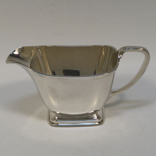 A heavy and elegant Sterling Silver pair of Art Deco sugar bowl and creamer set, having plain rectangular bodies with tapering sides and rounded corners, with cast scroll side-handles, and all sitting on pedestal feet. This handsome silver sugar and cream set was made by Charles Fletcher  of Sheffield in 1939. The dimensions of this fine hand-made silver Art Deco style sugar bowl and cream jug set are height of cream jug 8 cms (3 inches), width of sugar bowl (inc. handles) 18 cms (7 inches), and the total weight is approx. 461g (14.9 troy ounces).   