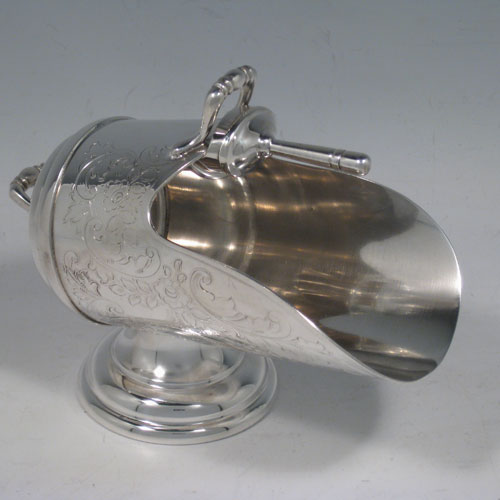 Antique Victorian silver-plated sugar scuttle, having a hand-engraved body with floral decoration, two cast scroll handles, an original scoop, and sitting on a pedestal foot. Made in ca. 1890. The dimensions of this fine hand-made silver-plated sugar scuttle are length 15 cms (6 inches), height 11.5 cms (4.5 inches), and width 7.5 cms (3 inches).   