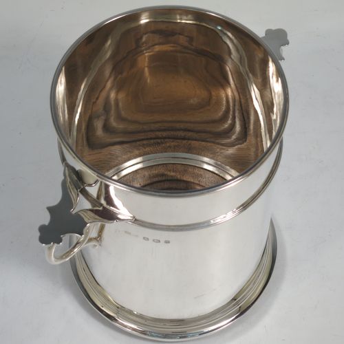 A very handsome Sterling Silver syphon stand, having a plain round body with straight sides, two ring side-handles with flat thumb-pieces, applied reeded borders and upper girdle, and sitting on a flat wood-turned coaster base. Made by James Dixon and Sons of Sheffield in 1933. The dimensions of this fine hand-made silver siphon stand are diameter 12 cms (4.75 inches), height 17 cms (6.75 inches), and it weighs approx. 450g (14.5 troy ounces).   