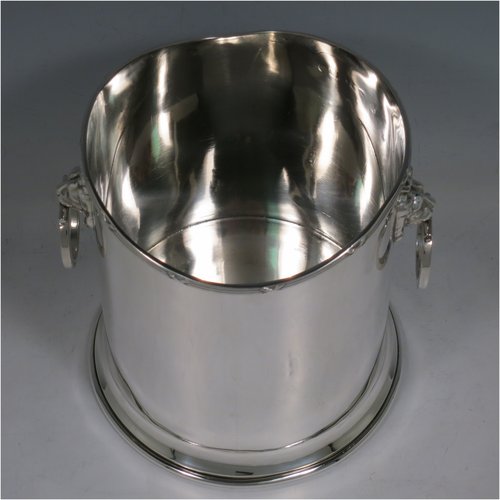 A Sterling Silver syphon stand, having a plain cylindrical body, two side-hinged ring handles with lion mask mounts, an applied reed and ribbon border, and sitting on a plain collet foot. Made by Britton, Gould & Co., of Birmingham in 1930. The dimensions of this fine hand-made silver siphon stand are diameter 13 cms (5 inches), height 14 cms (5.5 inches), and it weighs approx. 420g (13.5 troy ounces).   