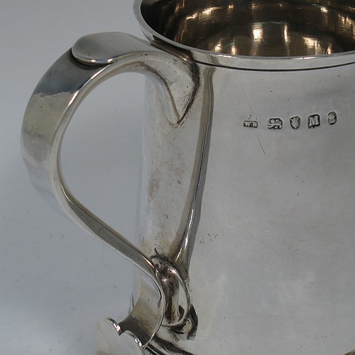 An Antique Georgian Sterling Silver pint tankard, having a plain round straight-sided body with hand-chased reeded borders, a scroll handle with heart-shaped terminal, and sitting on a collet foot. Made by Peter and William Bateman of London in 1804. The dimensions of this fine hand-made antique silver tankard are height 12 cms (4.75 inches), diameter at top 7.5 cms (3 inches), and it weighs approx. 315g (10.2 troy ounces).   