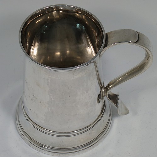 An Antique Georgian Sterling Silver pint tankard, having a plain round straight-sided body with hand-chased reeded borders, a scroll handle with heart-shaped terminal, and sitting on a collet foot. Made by Peter and William Bateman of London in 1804. The dimensions of this fine hand-made antique silver tankard are height 12 cms (4.75 inches), diameter at top 7.5 cms (3 inches), and it weighs approx. 315g (10.2 troy ounces).   