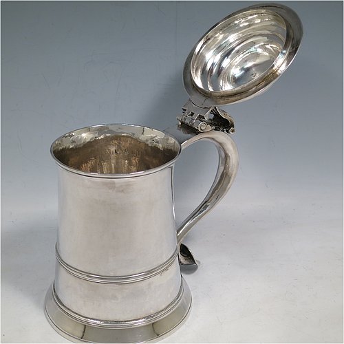 An Antique Georgian Sterling Silver lidded quart tankard, having a plain round straight-sided body, a hinged dome lid with cast scroll thumb-piece, a scroll handle with heart-shaped terminal, and sitting on a collet foot. Made by William Shaw & William Priest of London in 1758. The dimensions of this fine hand-made antique silver tankard are height 16.5 cms (6.75 inches), length 16.5 cms (6.5 inches), and it weighs approx. 620g (20 troy ounces).   