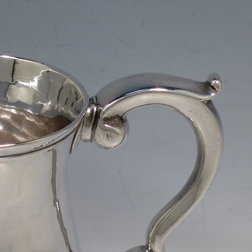 An Antique Georgian George II Sterling Silver three-quarter pint tankard or mug, having a plain round bellied body, a scroll handle, and sitting on a collet foot. Made by Robert Lucas of London in 1740. The dimensions of this fine hand-made antique silver three-quarter pint mug or tankard are height 11 cms (4.3 inches), diameter at top 7.5 cms (3 inches), and it weighs approx. 263g (8.5 troy ounces).    