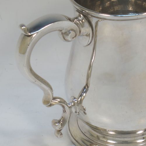 A very handsome Antique Georgian George II Sterling Silver pint tankard, having a plain round bellied body, a scroll handle with thumb-piece, and sitting on a pedestal foot. Made by William Cripps of London in 1755. The dimensions of this fine hand-made antique silver pint mug or tankard are height 11.5 cms (4.5 inches), diameter at top 8 cms (3 inches), and it weighs approx. 362g (11.7 troy ounces). Please note that this item is crested.