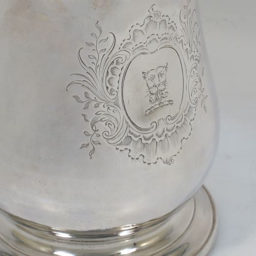 A very handsome Antique Georgian George II Sterling Silver pint tankard, having a plain round bellied body, a scroll handle with thumb-piece, and sitting on a pedestal foot. Made by William Cripps of London in 1755. The dimensions of this fine hand-made antique silver pint mug or tankard are height 11.5 cms (4.5 inches), diameter at top 8 cms (3 inches), and it weighs approx. 362g (11.7 troy ounces). Please note that this item is crested.