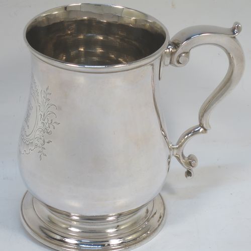 A very handsome Antique Georgian George II Sterling Silver pint tankard, having a plain round bellied body, a scroll handle with thumb-piece, and sitting on a pedestal foot. Made by William Cripps of London in 1755. The dimensions of this fine hand-made antique silver pint mug or tankard are height 11.5 cms (4.5 inches), diameter at top 8 cms (3 inches), and it weighs approx. 362g (11.7 troy ounces). Please note that this item is crested.