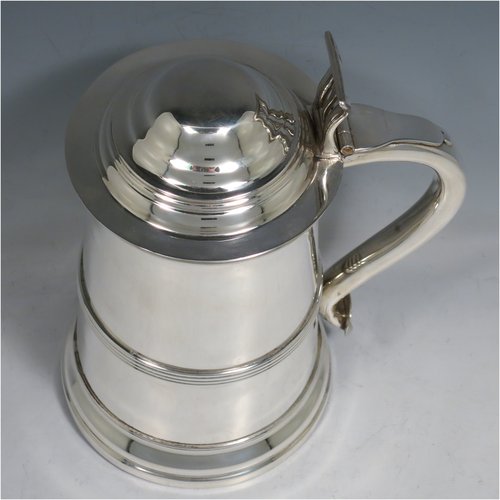 An Antique late Victorian Sterling Silver lidded quart tankard in a George I style, having a plain straight-sided body with an applied reeded band, a hinged dome lid with pierced thumb-piece, a scroll handle, and sitting on a reeded collet foot. Made by Elkington & Co., of Birmingham in 1900. The dimensions of this fine hand-made antique silver tankard are height 21.5 cms (8.5 inches), length 15 cms (6 inches), and it weighs approx. 682g (22 troy ounces).   