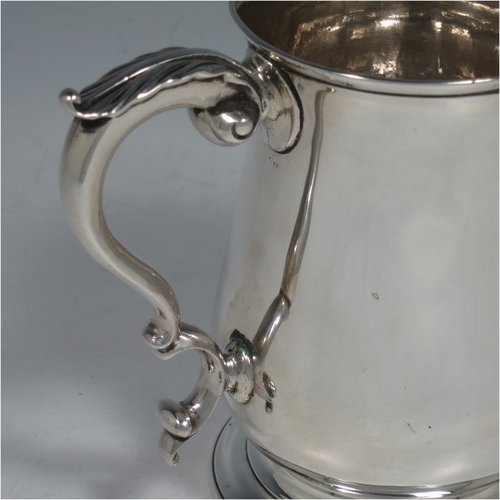 An Antique Georgian Sterling Silver pint tankard, having a plain round baluster body, a scroll handle, and sitting on a collet foot. Made by Fuller White of London in 1763. The dimensions of this fine hand-made antique silver tankard are height 12 cms (4.75 inches), diameter at top 8 cms (3 inches), and it weighs approx. 340g (11 troy ounces).   